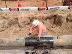 Worker performing controlled utility pipeline work